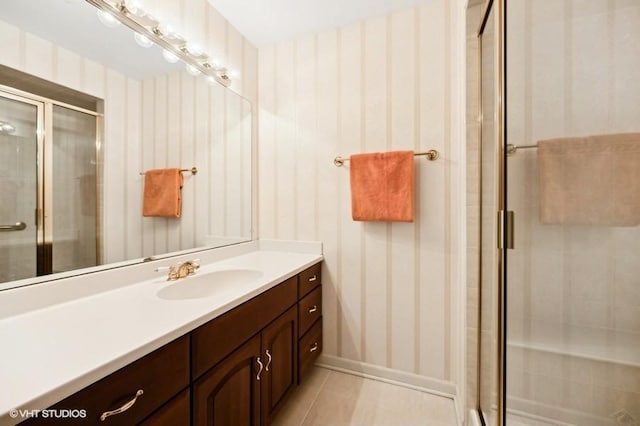 bathroom featuring tile patterned floors, vanity, and a shower with shower door