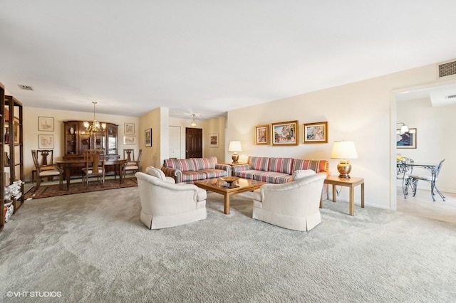 living room with carpet and a notable chandelier