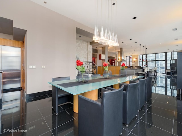 kitchen featuring a breakfast bar, island range hood, hanging light fixtures, a kitchen island, and expansive windows