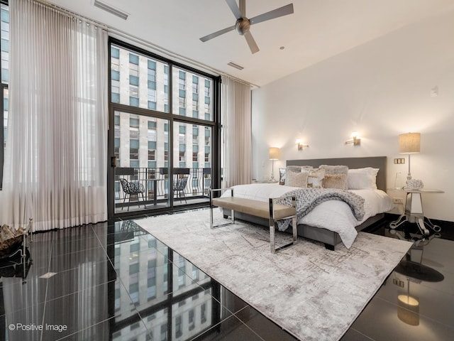 tiled bedroom featuring expansive windows, ceiling fan, and access to exterior