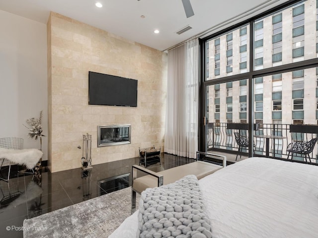 bedroom with a tile fireplace, floor to ceiling windows, and tile patterned flooring