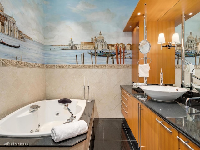 bathroom with vanity, tile patterned floors, tiled bath, and tile walls