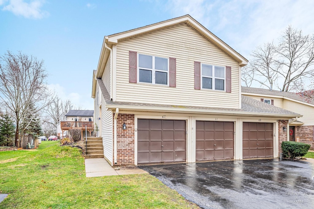 view of side of property with a yard, a garage, and a wooden deck