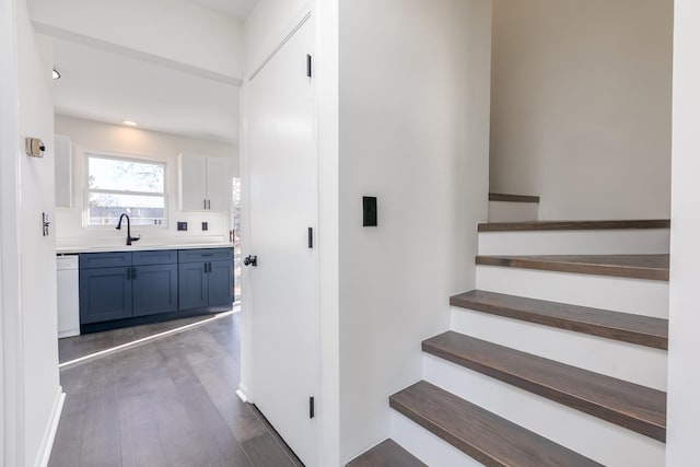 stairs featuring sink and wood-type flooring