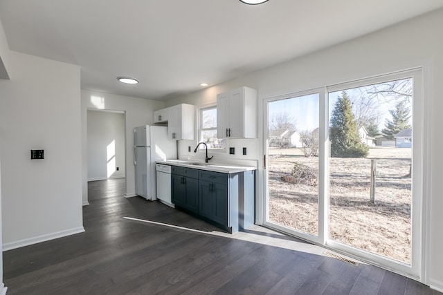 kitchen featuring sink, dark wood-type flooring, refrigerator, white cabinetry, and white dishwasher