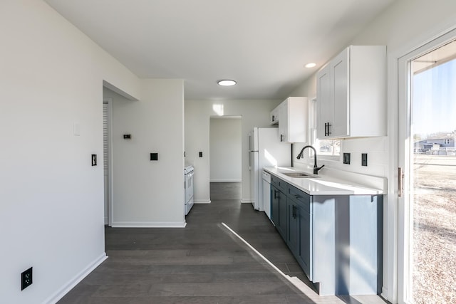 kitchen featuring white cabinetry, dark hardwood / wood-style flooring, sink, and white dishwasher