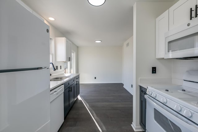 kitchen featuring dark hardwood / wood-style floors, white cabinetry, sink, and white appliances