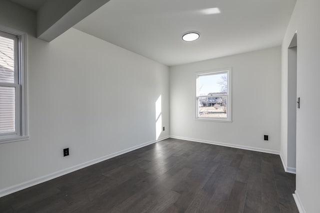 unfurnished room with dark wood-type flooring