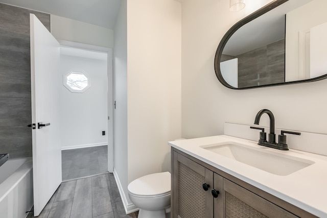 bathroom featuring vanity, toilet, and a bath