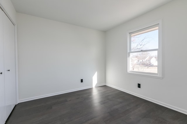 unfurnished bedroom featuring dark hardwood / wood-style flooring and a closet