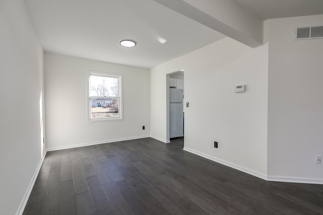 spare room with beamed ceiling and dark hardwood / wood-style flooring