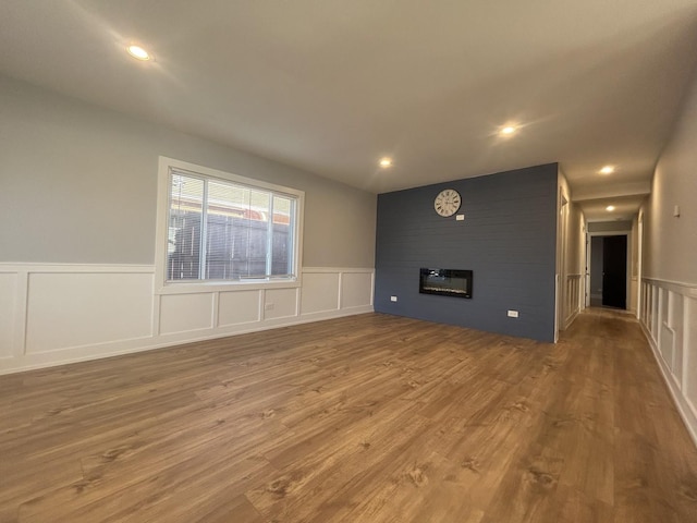 unfurnished living room with wood-type flooring and a large fireplace