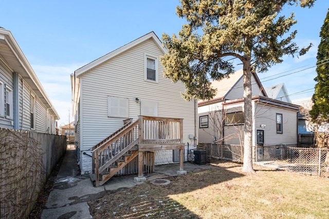 back of property featuring central AC and a yard