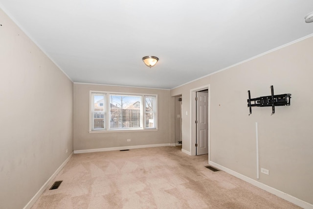 carpeted empty room featuring crown molding