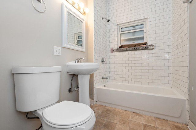 bathroom featuring tiled shower / bath combo and toilet