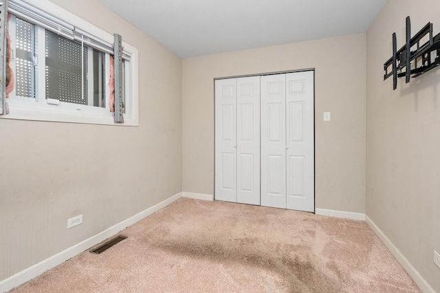 unfurnished bedroom with a closet and carpet flooring