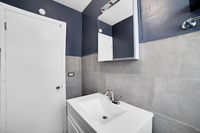 bathroom featuring vanity and tile walls