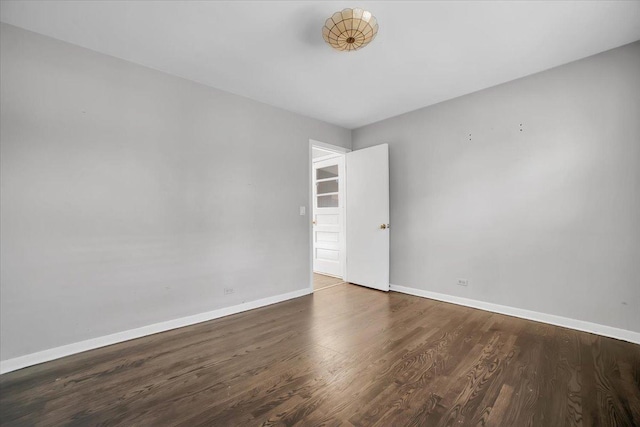 empty room with dark hardwood / wood-style flooring