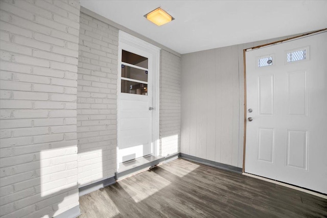 foyer with dark hardwood / wood-style flooring and wood walls