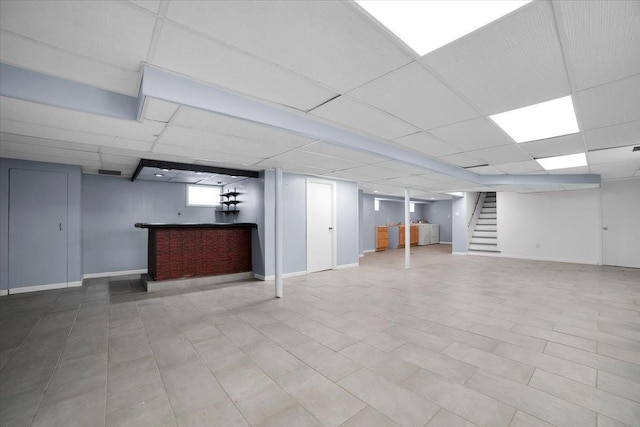 basement featuring bar and a drop ceiling