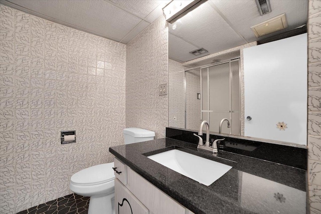 bathroom with vanity, toilet, and a shower with shower door