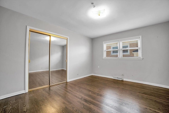 unfurnished bedroom featuring dark hardwood / wood-style flooring and a closet