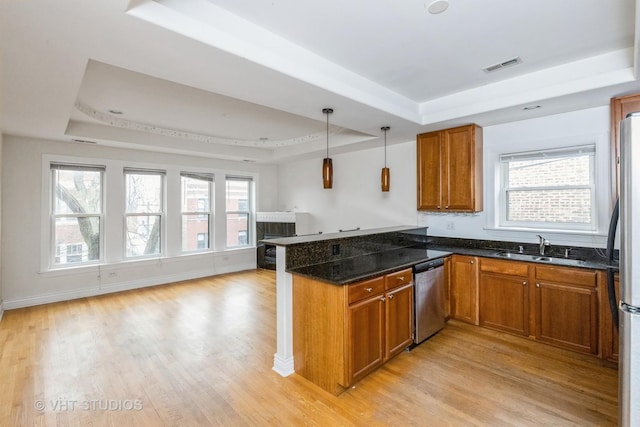 kitchen featuring stainless steel appliances, a tray ceiling, kitchen peninsula, and sink