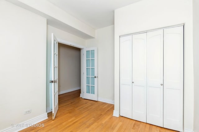 unfurnished bedroom featuring light hardwood / wood-style flooring and a closet