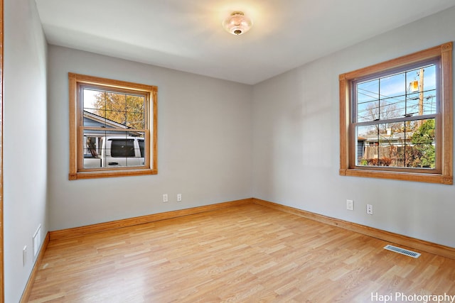 unfurnished room with light hardwood / wood-style floors and a wealth of natural light