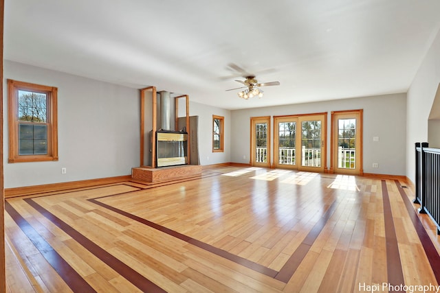 unfurnished living room featuring ceiling fan and light hardwood / wood-style floors