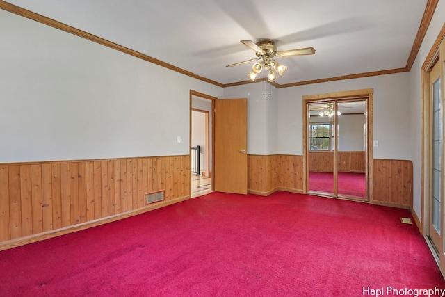 carpeted spare room with ornamental molding and ceiling fan