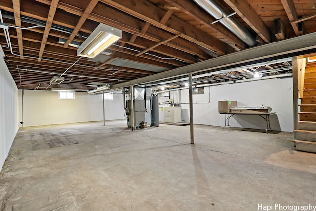 basement featuring heating unit and water heater