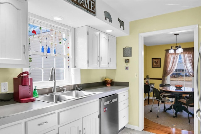 kitchen with white cabinets, decorative light fixtures, sink, and dishwasher