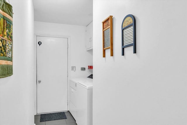 washroom featuring cabinets, washing machine and dryer, and light tile patterned flooring