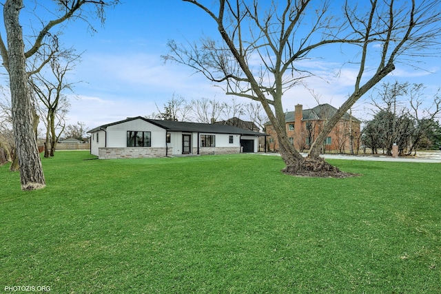 single story home with a garage and a front lawn