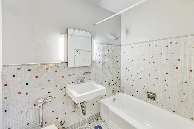 bathroom with tile patterned flooring, sink, tile walls, and washtub / shower combination