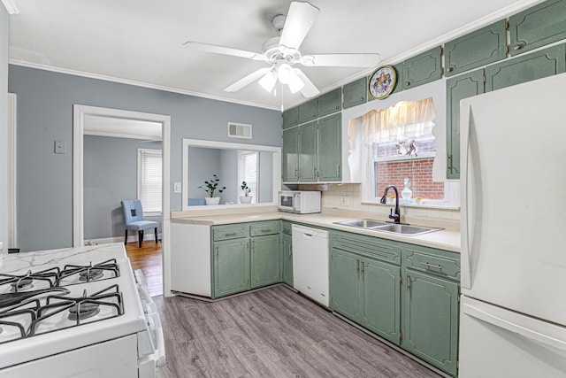 kitchen with sink, white appliances, crown molding, tasteful backsplash, and green cabinetry