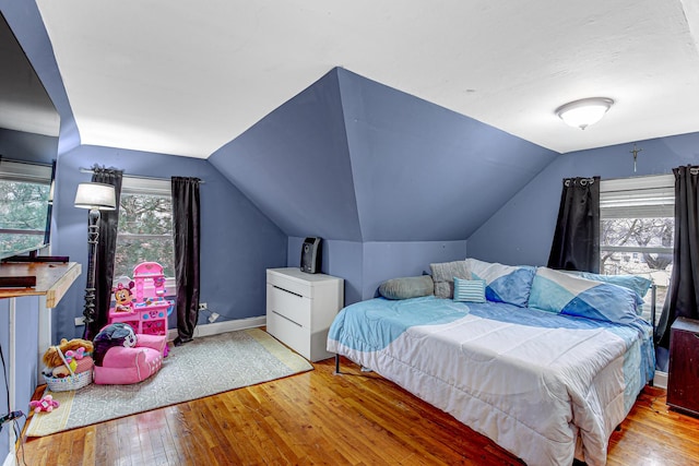 bedroom with lofted ceiling and light hardwood / wood-style flooring