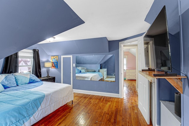 bedroom featuring hardwood / wood-style flooring and vaulted ceiling