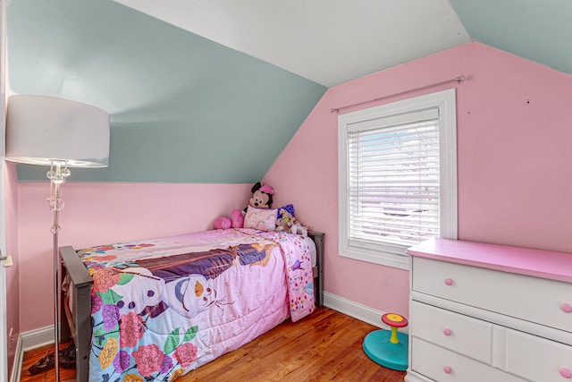 bedroom with vaulted ceiling and light wood-type flooring