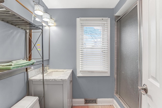 bathroom with vanity, an enclosed shower, and toilet