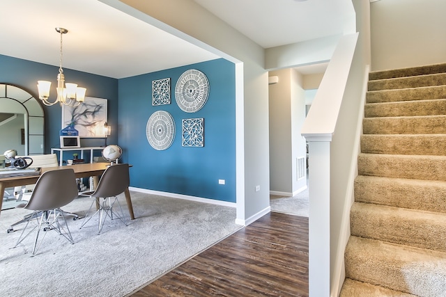 dining space with hardwood / wood-style flooring and an inviting chandelier