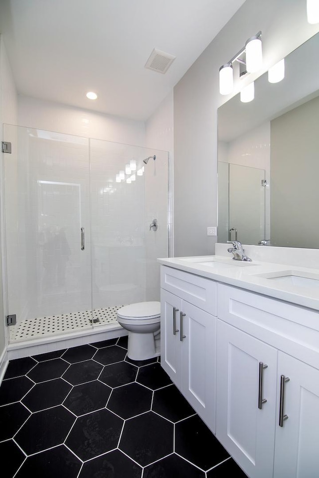 bathroom featuring vanity, an enclosed shower, and toilet