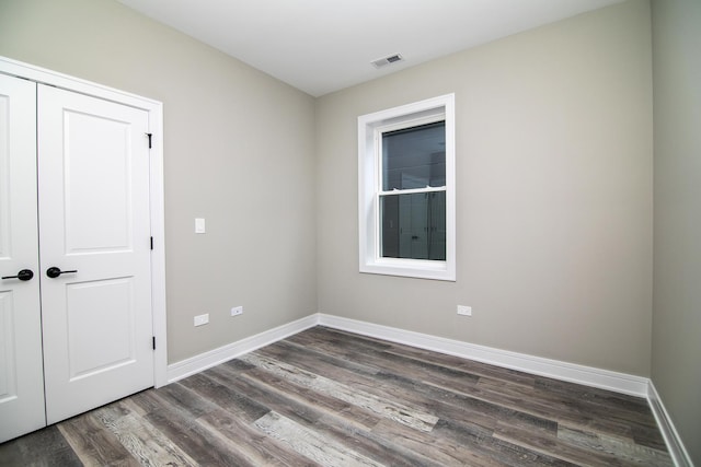 unfurnished room featuring dark wood-type flooring