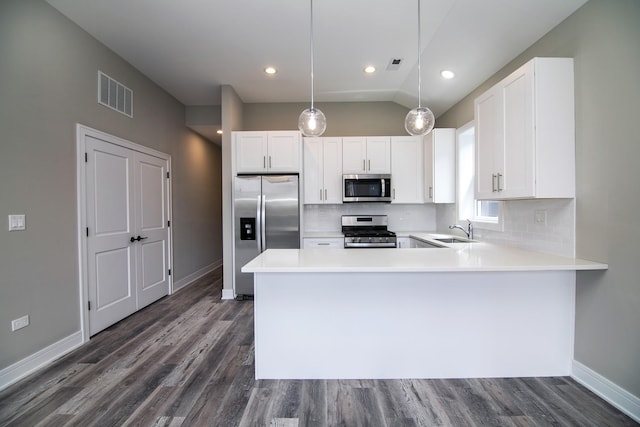 kitchen with sink, decorative light fixtures, kitchen peninsula, stainless steel appliances, and white cabinets