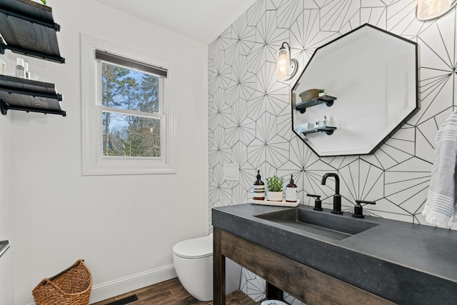 bathroom featuring hardwood / wood-style flooring, toilet, and sink