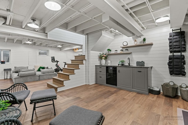 bar with wine cooler, sink, light wood-type flooring, and gray cabinetry