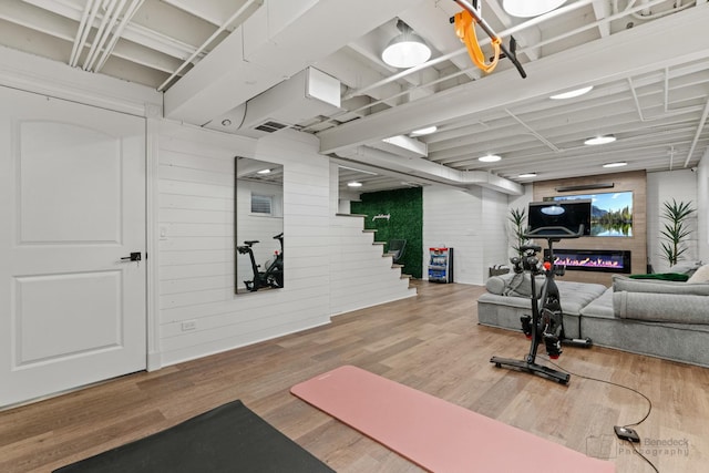 exercise room featuring wooden walls and hardwood / wood-style floors