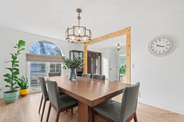 dining area with an inviting chandelier and light wood-type flooring