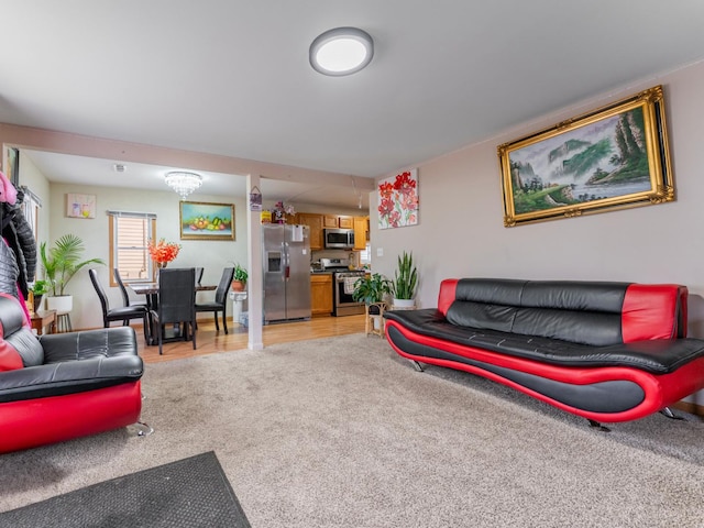 living room featuring a notable chandelier and light colored carpet